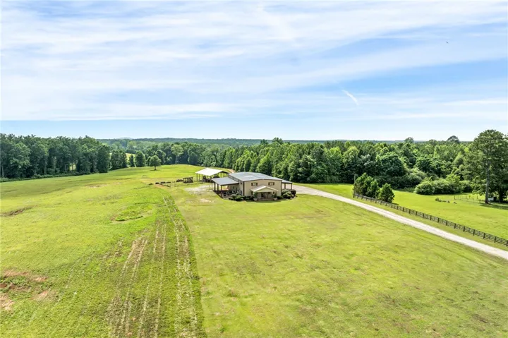 An aerial perspective reveals a vast estate with abundant open pasture and a long private driveway leading to the main residence.