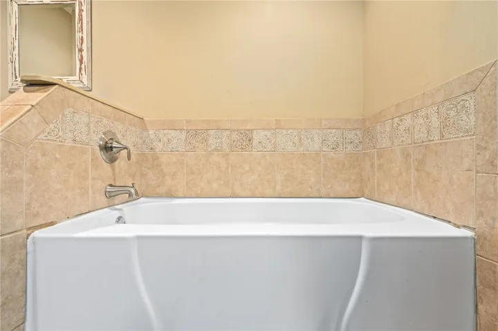 Relax and unwind in this serene soaking tub, framed by classic tiled walls.