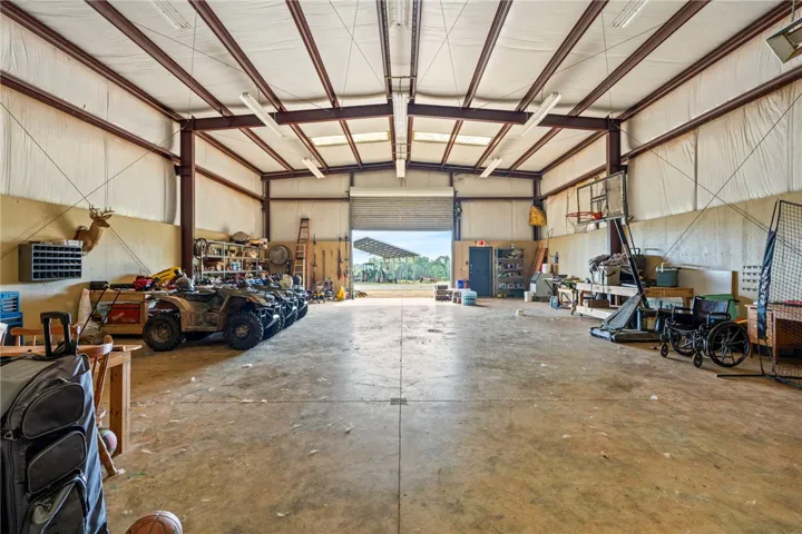 A spacious utility building offers ample room for vehicles and equipment, featuring a large roll-up door.