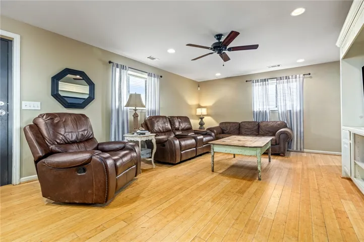 A comfortable living space boasts recessed lighting and hardwood floors.