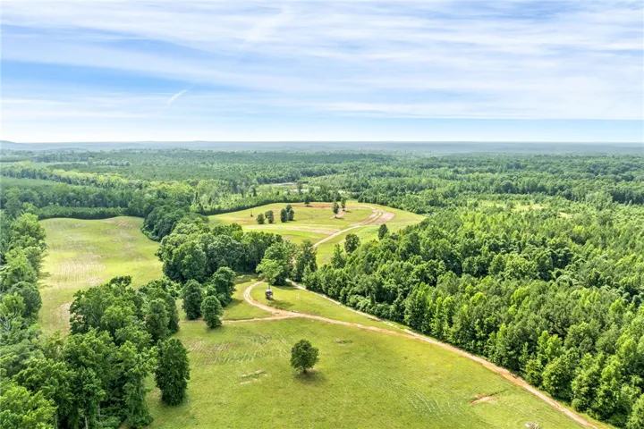 Vast green acreage featuring diverse woodland and open fields, ideal for a serene retreat.