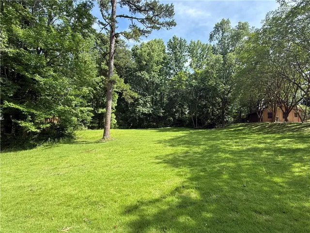 A verdant expanse of lawn provides a natural, secluded setting surrounded by mature trees.