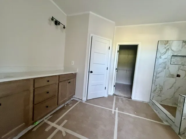 A spacious primary bathroom boasts a dual vanity, an inviting walk-in shower, and ample storage.