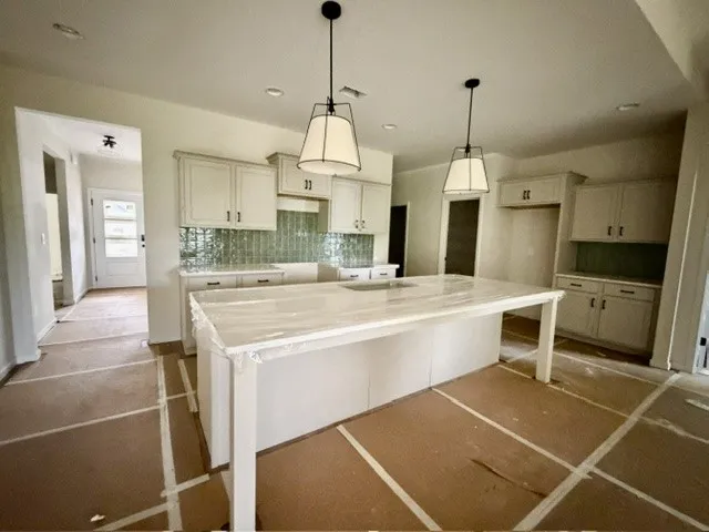 A well-lit kitchen with a large island offers ample space for culinary creations.