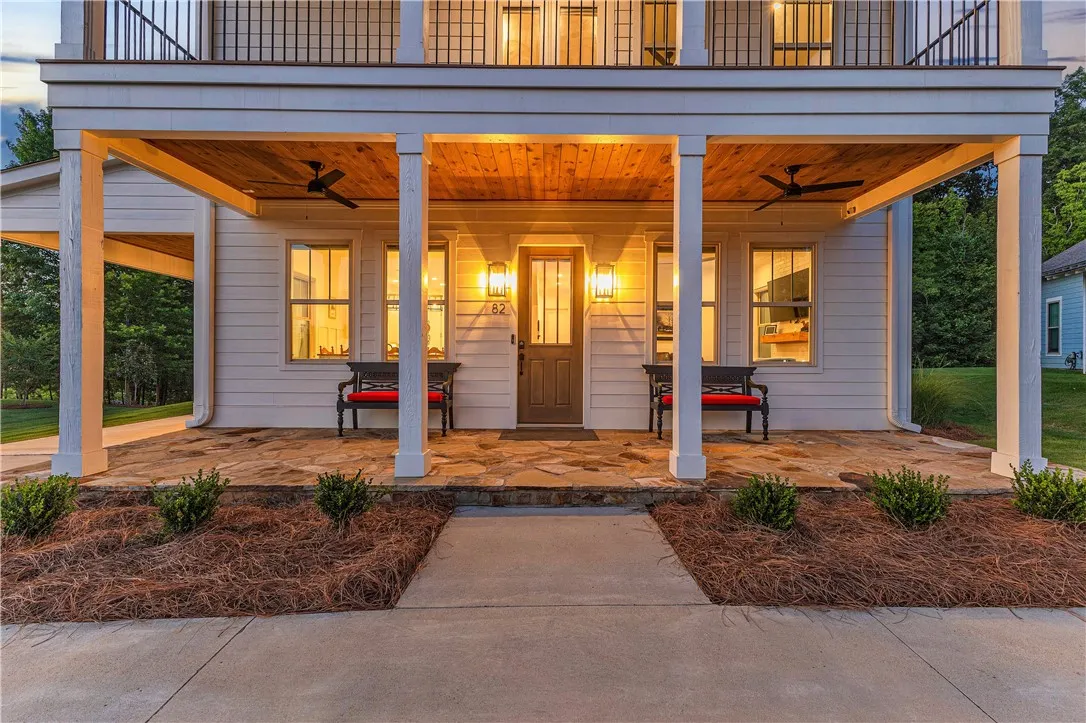 A welcoming front entrance features a covered porch with rich wood accents and stately columns.
