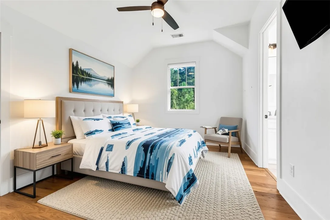 Hardwood floors and vaulted ceilings create an inviting bedroom sanctuary.
