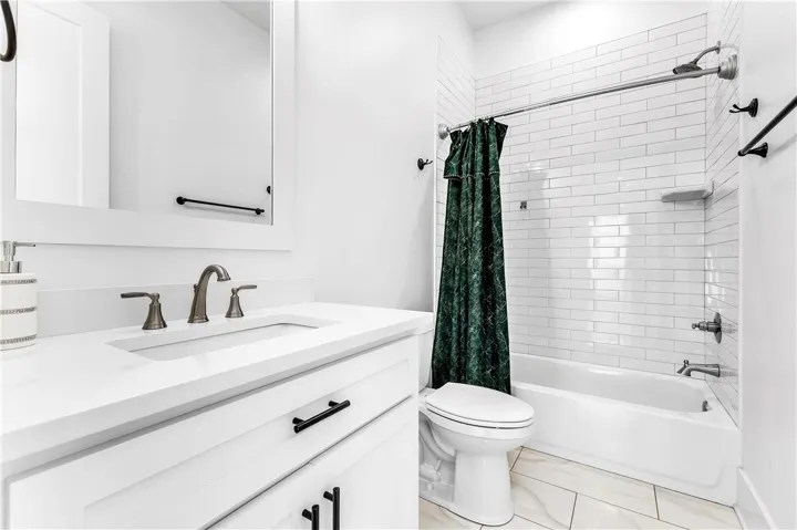 A well-appointed bathroom features a modern vanity with elegant fixtures and a subway-tiled shower.