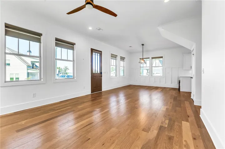Natural light floods this spacious room, highlighting the warm wood flooring and clean lines throughout.