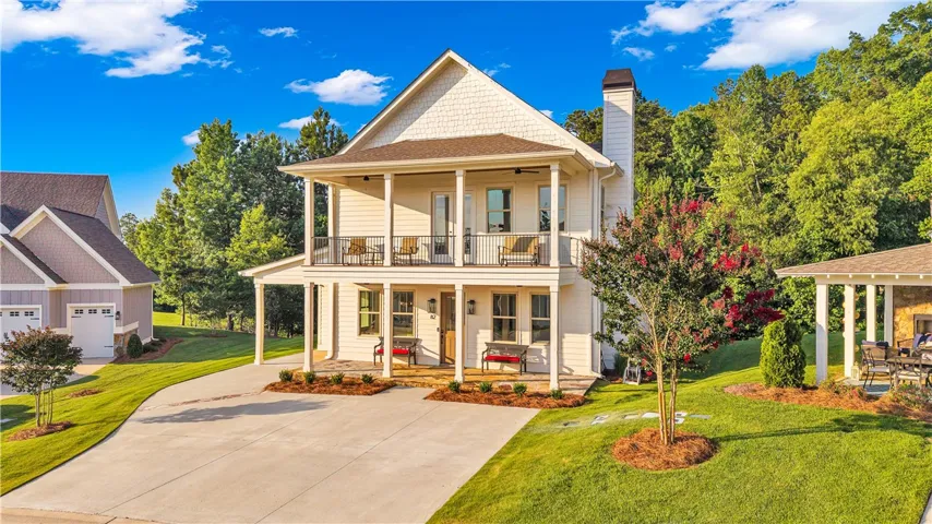 A charming cottage-style residence with multiple balconies and inviting curb appeal.