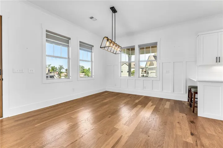 A luminous space with gleaming hardwood floors, ready for personalized touches.