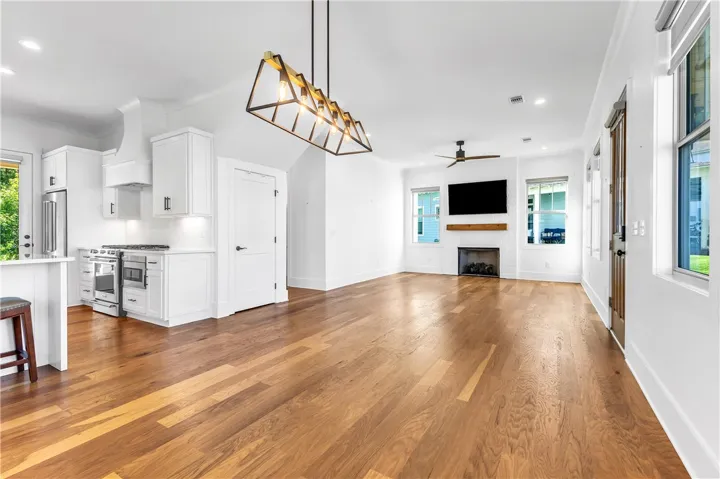 An open concept design seamlessly connects the kitchen and living area, featuring rich hardwood floors.