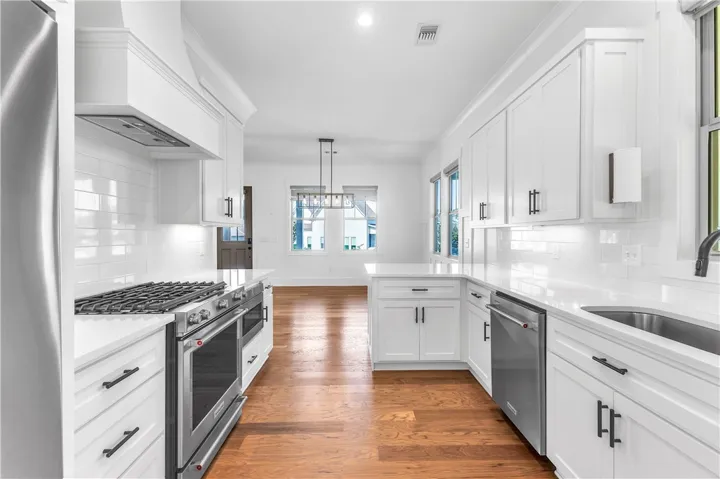 Culinary dreams come to life in this kitchen, featuring sleek stainless steel appliances and abundant white cabinetry.