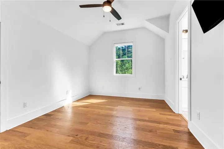 Hardwood flooring extends throughout this light-filled room, offering comfort and style.