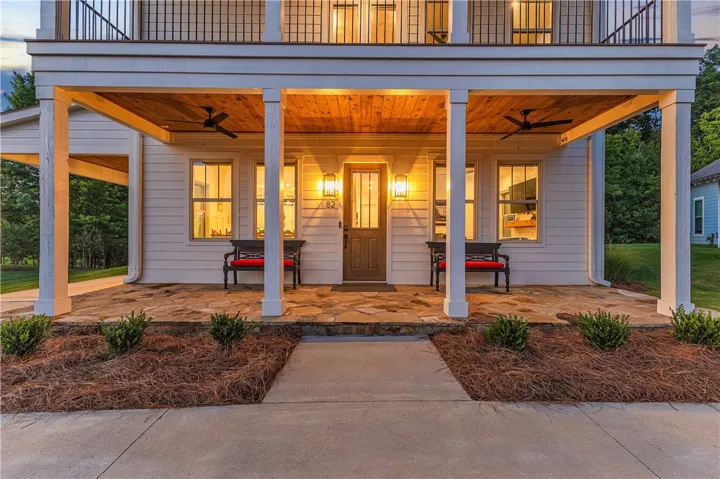 A welcoming front entrance features a covered porch with rich wood accents and stately columns.
