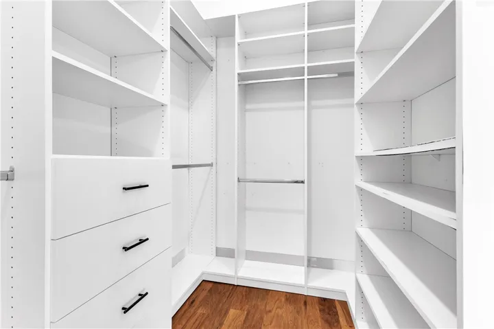Ample storage solutions abound in this well-organized, spacious walk-in closet.