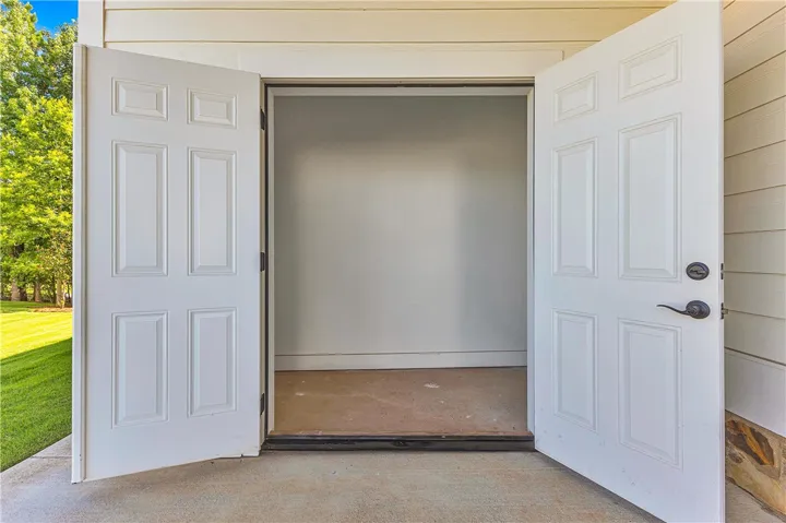 Double doors open to a spacious, undeveloped interior, offering versatile potential.