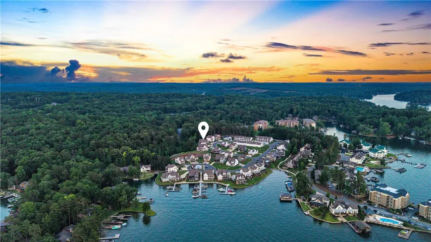 An aerial perspective reveals waterfront homes nestled amidst abundant trees, offering serene lake views at dusk.