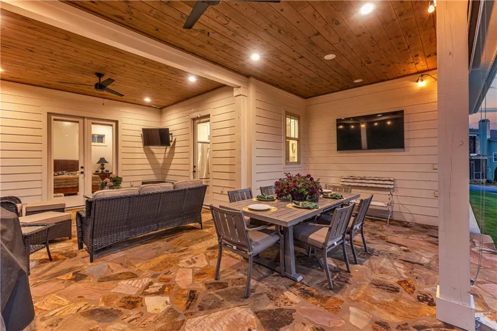 An inviting stone patio with wood ceiling and recessed lighting awaits outdoor entertaining.