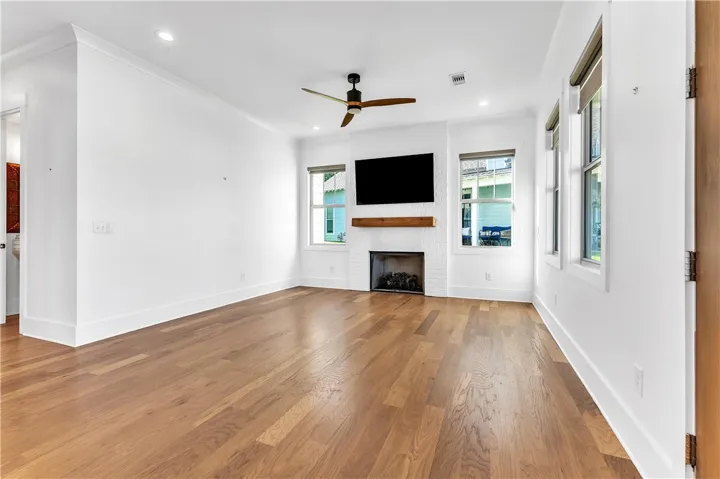 A refined living space showcases hardwood flooring and a stylish fireplace with an integrated entertainment area.