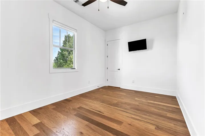 Hardwood flooring extends throughout this well-lit room, ready for personalization.