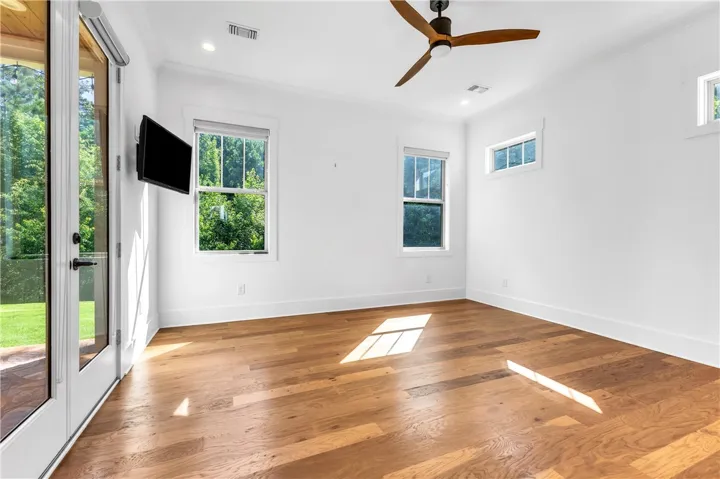 Hardwood floors and generous windows create a light-filled, airy living space with an outdoor connection.