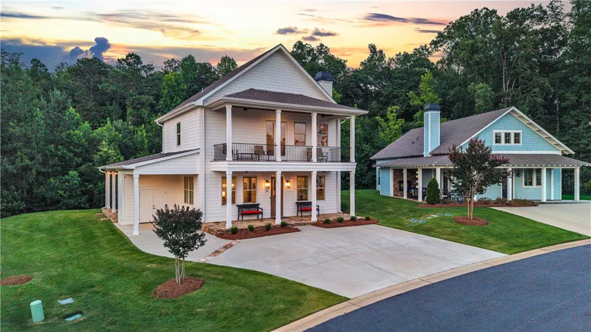 A striking property with multiple balconies and a covered entrance, nestled amidst lush, mature trees.