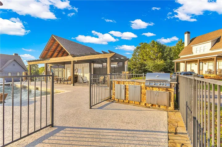 An inviting outdoor kitchen and pergola offer ample space for entertaining by the community pool.