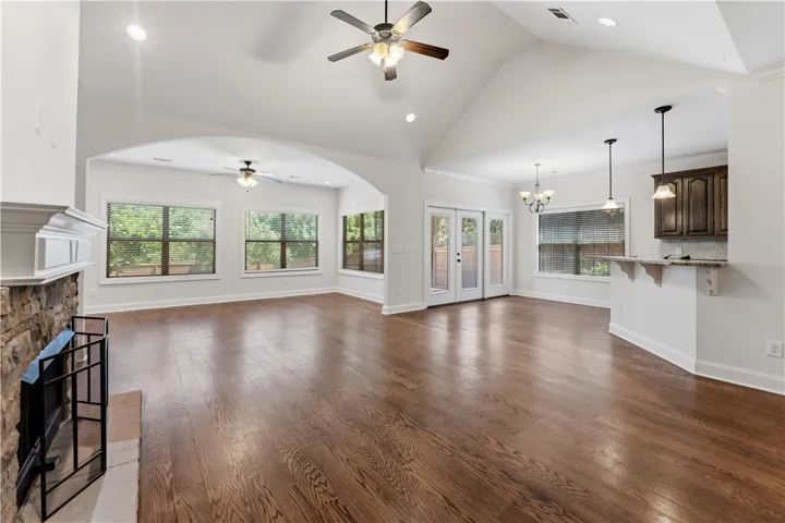 Refined wood floors grace this open-concept living space with a stately fireplace and ample natural light.