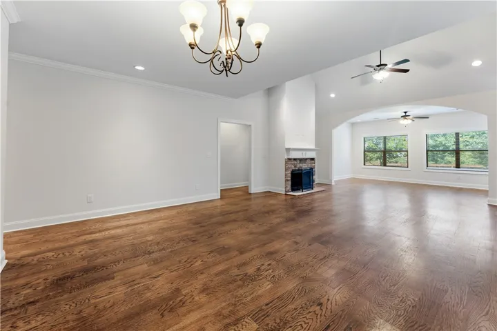 Rich hardwood floors span this open-concept living space with a stately fireplace and vaulted ceilings.