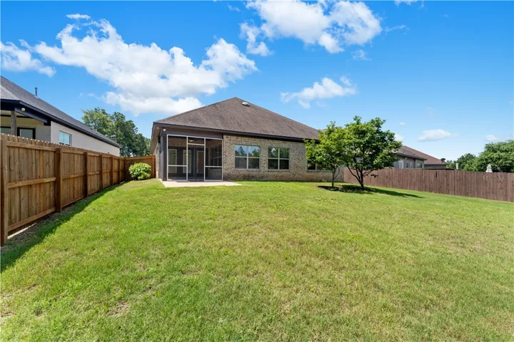 A spacious, enclosed backyard with a screened porch for comfortable outdoor living.