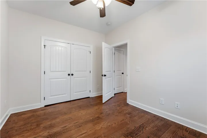 Rich hardwood floors complement bright white trim in this adaptable living space.