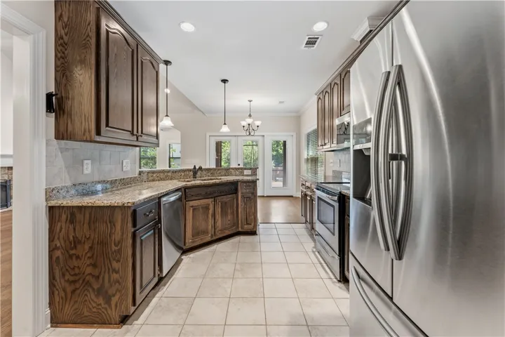 Culinary delights await in this modern kitchen with ample counter space and French doors leading to the exterior.