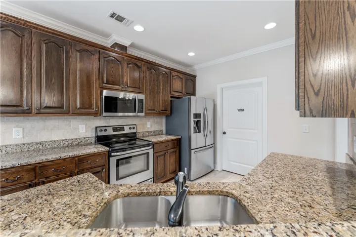 Enjoy seamless meal preparation with generous granite countertops and modern appliances in this inviting kitchen.