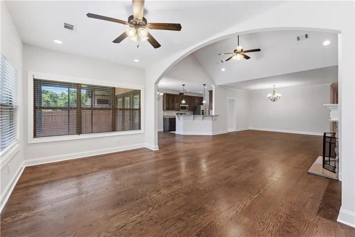 Rich hardwood floors unite an inviting open concept living space, anchored by a prominent fireplace.