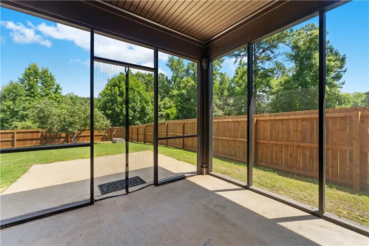 A screened patio overlooks a private, fenced yard, perfect for outdoor leisure.