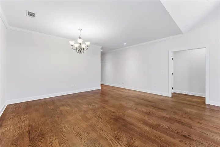Elegant hardwood flooring grounds a spacious, open area perfect for flexible living.