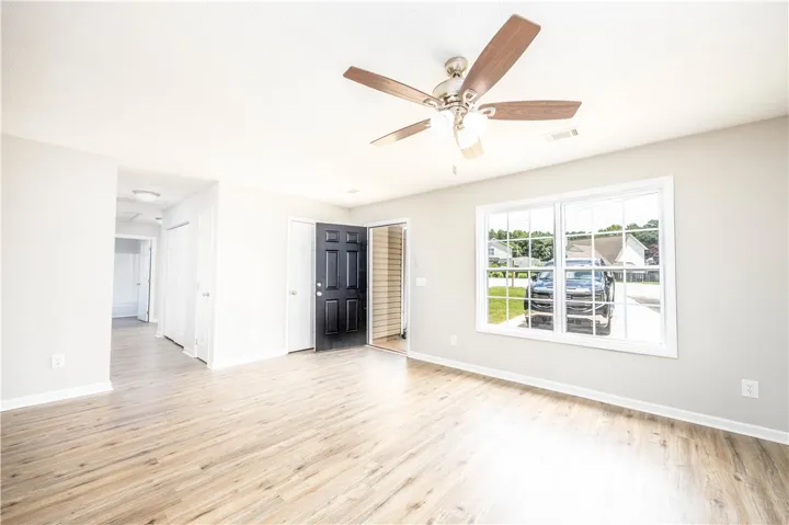 This large living room has new lvp flooring, new paint and a new ceiling fan.