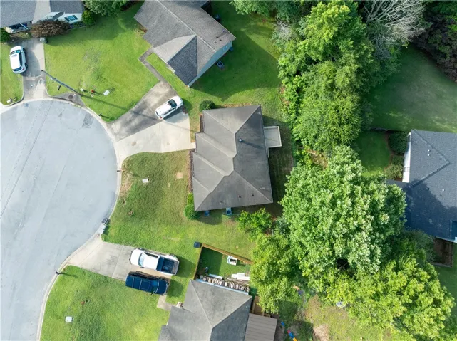 An aerial perspective reveals a cul-de-sac neighborhood with homes nestled amidst mature trees and verdant lawns.