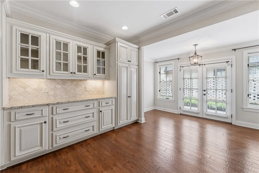 A well-lit breakfast area boasts rich hardwood flooring and convenient access to an outdoor space.