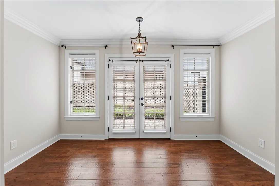 Rich hardwood flooring complements pristine white walls in this welcoming sunlit interior.
