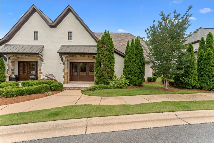A striking facade with prominent gables and inviting stone archways greets visitors to this residence.