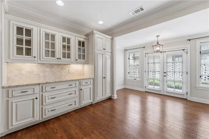A well-lit breakfast area boasts rich hardwood flooring and convenient access to an outdoor space.