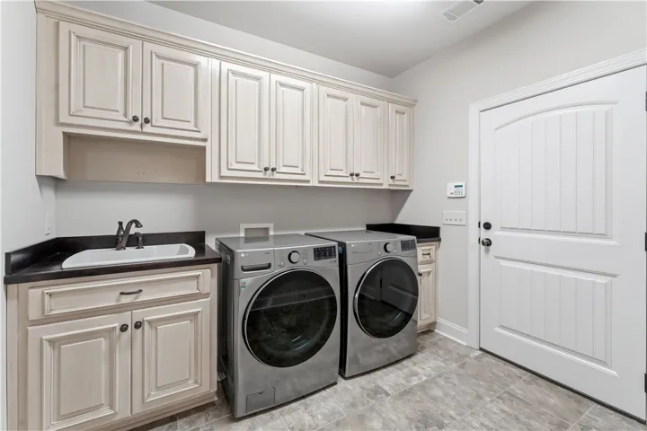 Ample storage and a utility sink equip this convenient laundry room for all household needs.