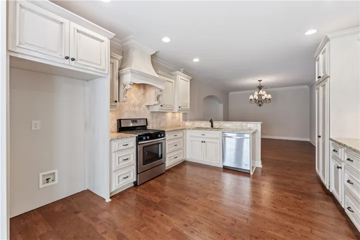 A well-appointed kitchen features stainless steel appliances, granite countertops, and hardwood flooring.
