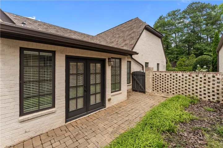 A charming brick patio with a decorative privacy wall connects to this pristine residence.