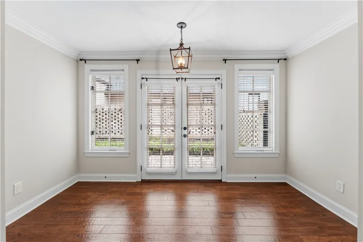Rich hardwood flooring complements pristine white walls in this welcoming sunlit interior.