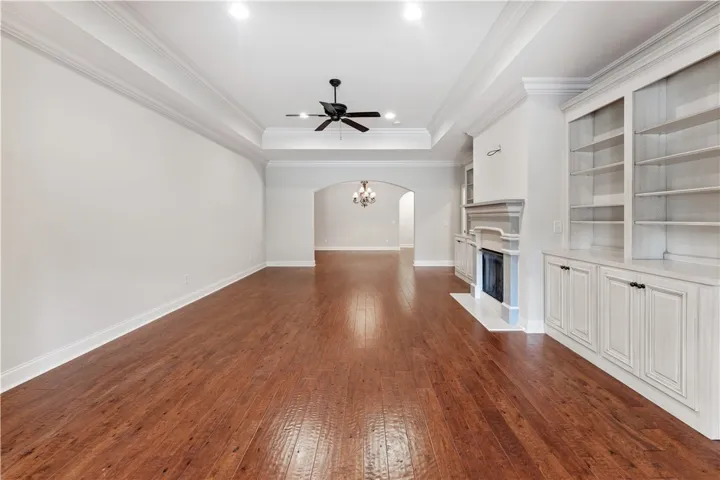 Rich hardwood floors complement a refined fireplace and built-in shelving.