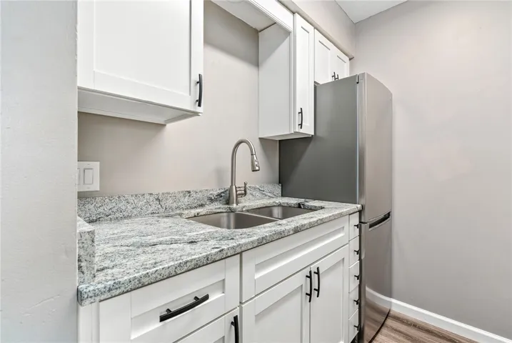 Modern kitchen with sleek white cabinetry and granite countertops offers both style and function.