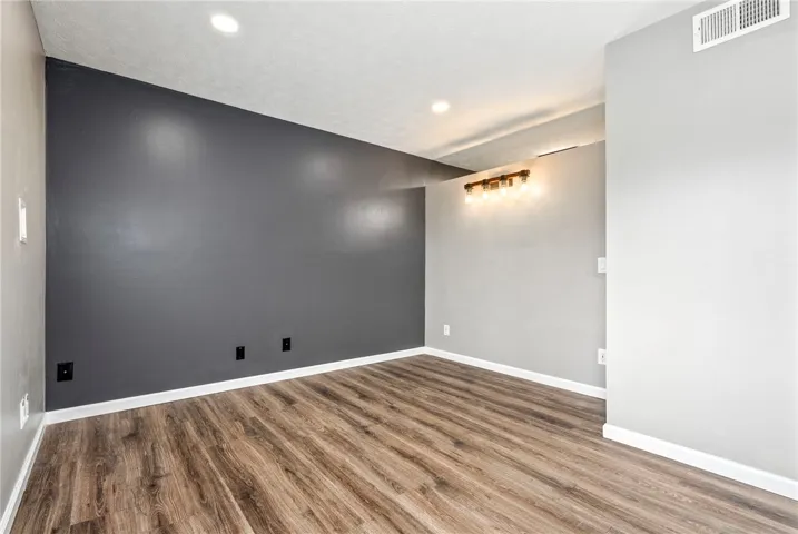 Rich wood flooring complements neutral walls, providing a versatile foundation for any aesthetic.