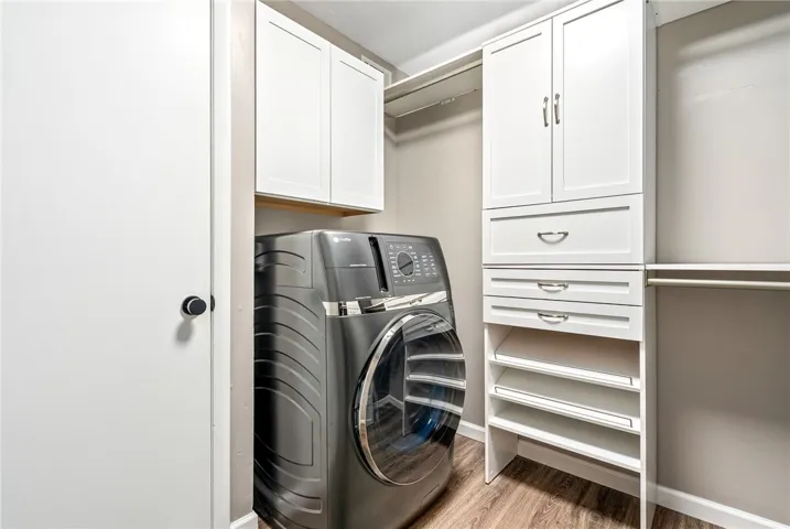 A dedicated laundry space boasts built-in cabinetry and practical hanging rods for convenience.
